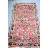 AN ANTIQUE RED GROUND PERSIAN RUG, decorated with extensive foliage. 152 cm x 79 cm.