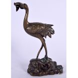A JAPANESE BRONZE OKIMONO IN THE FORM OF A STANDING BIRD, formed upon a rocky outcrop. 26 cm high.