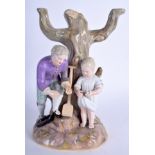 A 19TH CENTURY MEISSEN PORCELAIN FIGURE OF A BOY AND GIRL modelled upon a naturalistic base. 20 cm