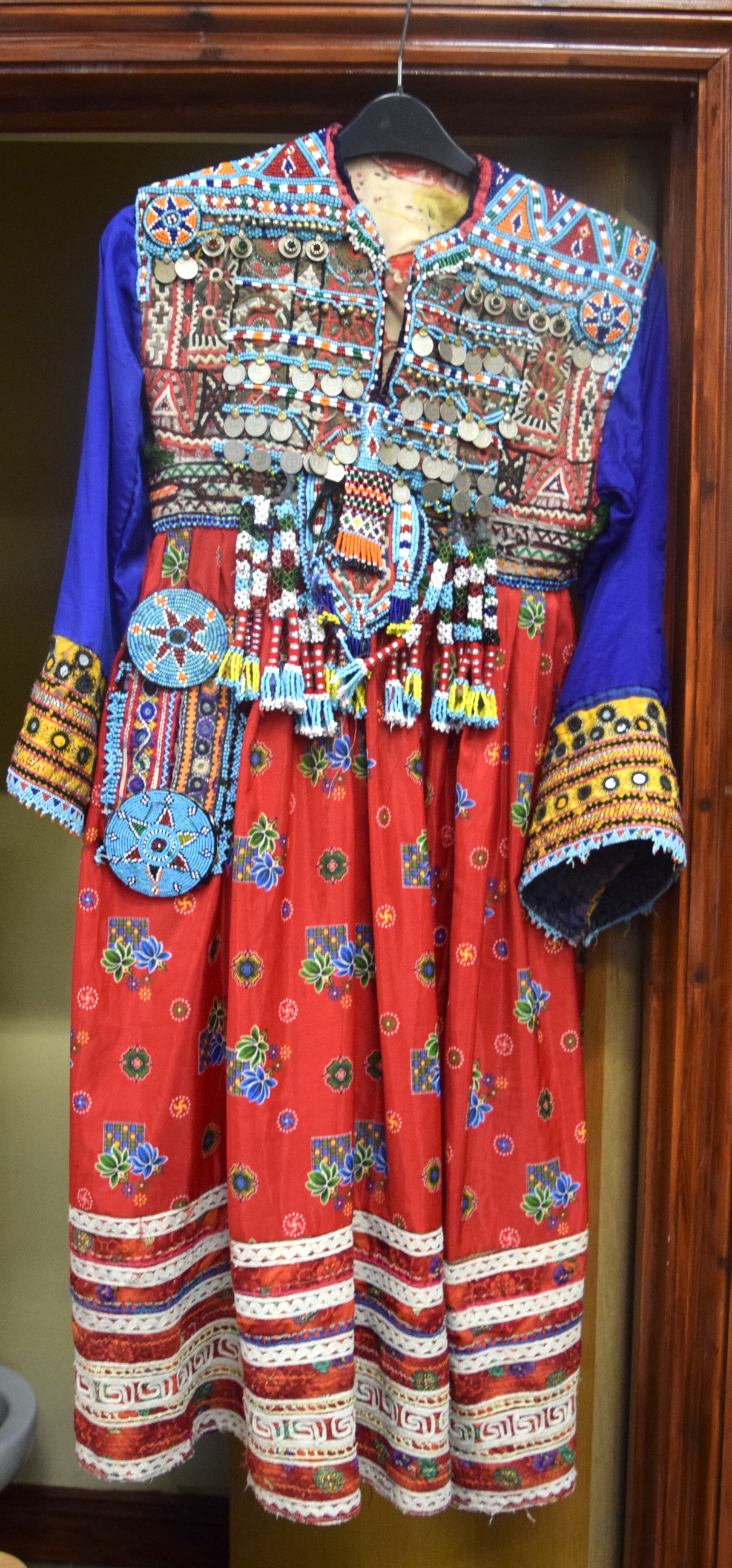 AN AFGHAN BEADWORK ROBE OR DRESS, decorated with foliage and coinage.