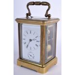 AN ANTIQUE REPEATING BRASS CARRIAGE CLOCK with white enamel dial. 15 cm high inc handle.