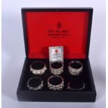 A COLLECTION OF SIX BOXED SILVER NAPKIN RINGS BY JAWAHIR OMAN JEWELLERS. Total silver weight approx