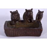 A JAPANESE BRONZE OKIMONO IN THE FORM OF THREE PIGS, modelled drinking form a trough, signed. 4.5 c