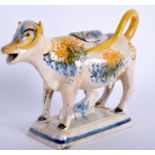 AN 18TH/19TH CENTURY SPONGEWARE POTTERY COW CREAMER AND COVER. 15 cm wide.