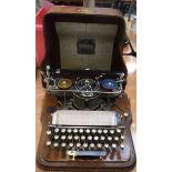 AN ANTIQUE HAMMOND TYPEWRITER, contained within an oak case. 36 cm wide.
