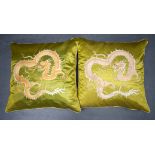 A PAIR OF EARLY 20TH CENTURY CHINESE SILKWORK CUSHIONS depicting dragons in pursuit of a flaming pe