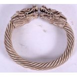 A CHINESE WHITE METAL BANGLE, in the form of opposing dragon heads. 9.5 cm wide.