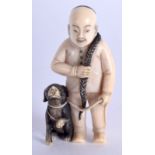 AN EARLY 20TH CENTURY JAPANESE MEIJI PERIOD CARVED IVORY NETSUKE modelled as a male and hound. 4.5