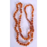 AN EARLY/MID 20TH CENTURY AMBER BEAD NECKLACE, formed with facetted beads. 80 cm long and weight 29