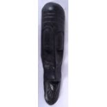 A TRIBAL WOODEN MASK, carved with an elongated face. 49 cm long.