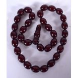 A CHERRY AMBER NECKLACE, formed with flattened spherical beads. 44 cm long and weight 37 grams.