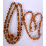 AN EASTERN AMBER TYPE NECKLACE, together with a similar smaller example. Longest 100 cm. (2)