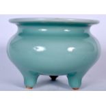 A CELADON GLAZED PORCELAIN CENSER, formed tri legged with a flared lip. 11 cm wide.