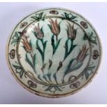 A 19TH CENTURY TURKISH MIDDLE EASTERN IZNIK FAIENCE DISH painted with five sparse floral sprigs. 23