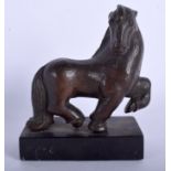 AN UNUSUAL BRONZE FIGURE OF A ROAMING HORSE modelled with one leg raised. 11 cm x 11 cm.