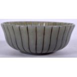 A CARVED EASTERN JADE BOWL, formed with ribbed body. 8 cm wide.