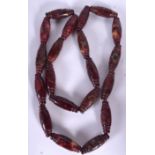 AN EASTERN HARDSTONE NECKLACE, carved with mask head detail. 94 cm long.