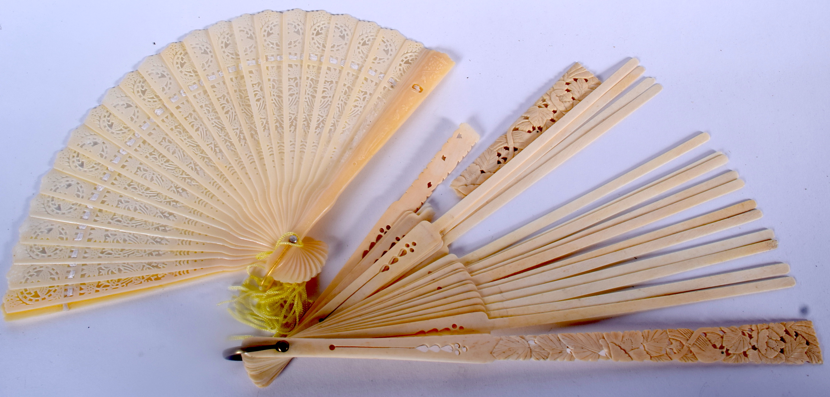 AN EARLY 20TH CENTURY CHINESE CARVED IVORY FAN, together with another fan. Largest 30 cm long. (2)