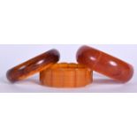 A 20TH CENTURY AMBER TYPE SECTIONAL BRACELET, together with two bangles. (3)