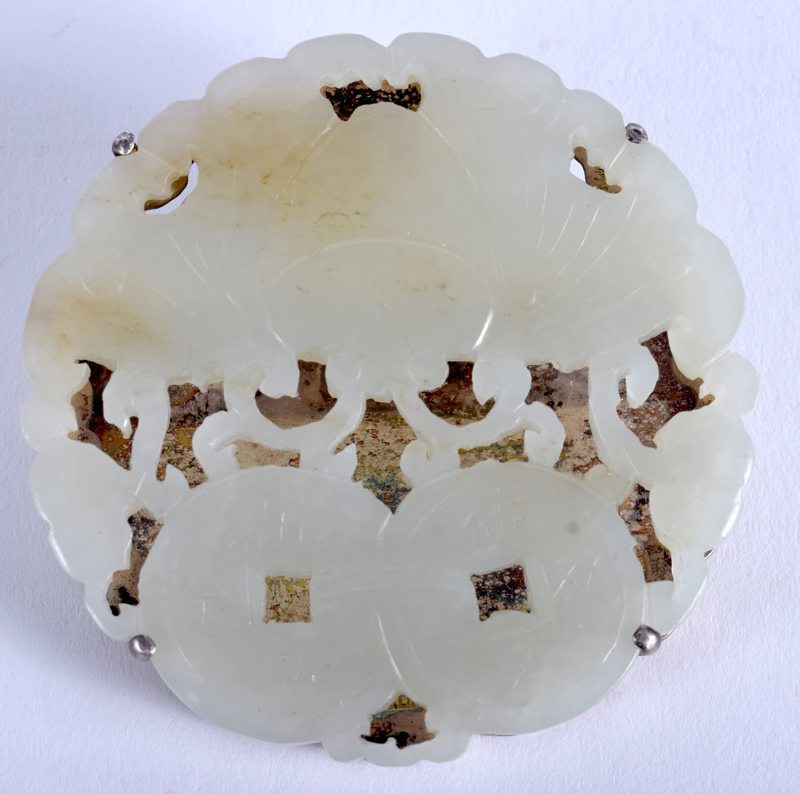 A 19TH CENTURY CHINESE CARVED GREEN JADE RETICULATED PLAQUE Qing, with attached silver clip. 5.5 cm