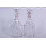 A PAIR OF 19TH CENTURY THREE RING GLASS DECANTERS, formed with facetted body. 24.5 cm high.