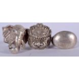 THREE CHINESE WHITE METAL RINGS, one in the form of an elephant. (3)