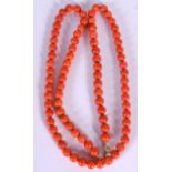 A SPHERICAL RED CORAL BEAD NECKLACE, formed with a yellow metal clasp. 62 cm long.