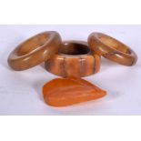 AN ANTIQUE BONE RING, together with two amber type rings and another carving. (4)