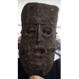 A TRIBAL HIDE MASK, decorated with tin fittings. 36 cm x 18.5 cm.