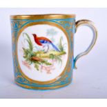 A 18TH CENTURY SEVRES BLUE CELESTE MUG painted with two oval landscapes both containing birds in a