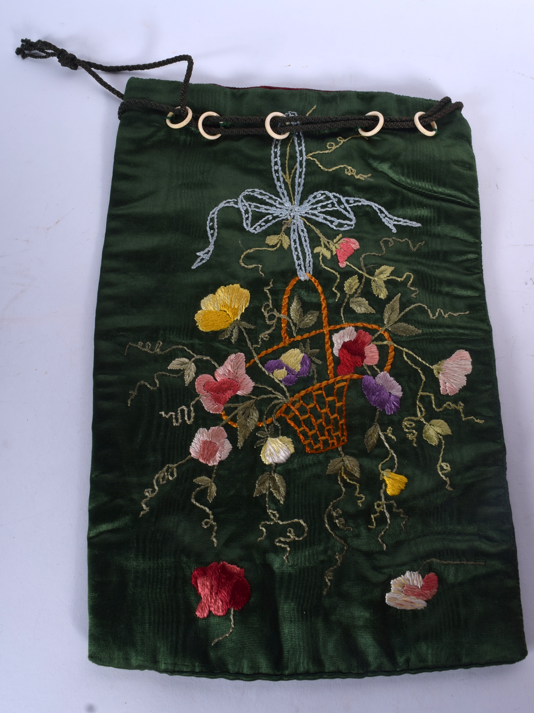A SILK EMBROIDERED BAG, decorated with flowers in a basket. 31 cm x 20 cm.