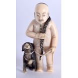 AN EARLY 20TH CENTURY JAPANESE MEIJI PERIOD CARVED IVORY NETSUKE modelled as a male and hound. 4.5 c