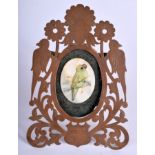 A VINTAGE FRAME with a painted ivory bird. 7 cm x 9 cm.