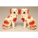 A PAIR OF VICTORIAN STAFFORDSHIRE POTTERY SMALL SPANIELS, modelled with free standing forelegs and