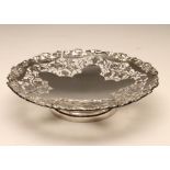 A LOW PEDESTAL SILVER FRUIT DISH, maker's mark S & W, Sheffield 1937, of shaped circular form with