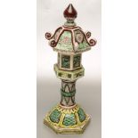 AN EARTHENWARE KANGXI STYLE STAND AND COVER painted in green, yellow and brown with stylised panels,