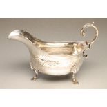 AN ARTS AND CRAFTS SILVER SAUCE BOAT, maker Williams Ltd., Birmingham 1909, the heavily planished