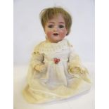 A Kammer & Reinhardt bisque head character doll with blue glass sleeping eyes, open mouth and teeth,