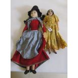 A Norah Wellings Welsh costume doll wearing a black felt hat, red velveteen dress and blue gingham