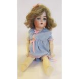 A Kammer & Reinhardt bisque head doll with blue glass sleeping eyes, open mouth and teeth, brown