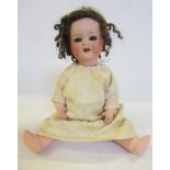 An Armand Marseille bisque head doll with blue glass sleeping eyes, open mouth and teeth, brown