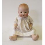 An Armand Marseille bisque head baby doll with blue glass eyes, open mouth and teeth, moulded