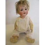 An Armand Marseille bisque head character doll, with blue glass sleeping eyes, open mouth and teeth,