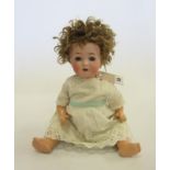 An Ernst Heubach bisque head doll with blue glass sleeping eyes, open mouth and teeth, curly brown