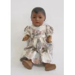 An Ernst Heubach bisque head mulatto doll with brown glass sleeping eyes, open mouth and teeth,