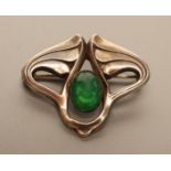 A JUGENDSTIL BROOCH, the pair of stylised wings centred by a green oval cabochon, two applied