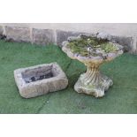 A COMPOSITION STONE BIRD BATH, modelled as a scallop shell, on wrythen fluted socle and scrolled