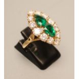 AN EMERALD AND DIAMOND MARQUISE SHAPE CLUSTER RING, the two pear cut emeralds centrally claw set