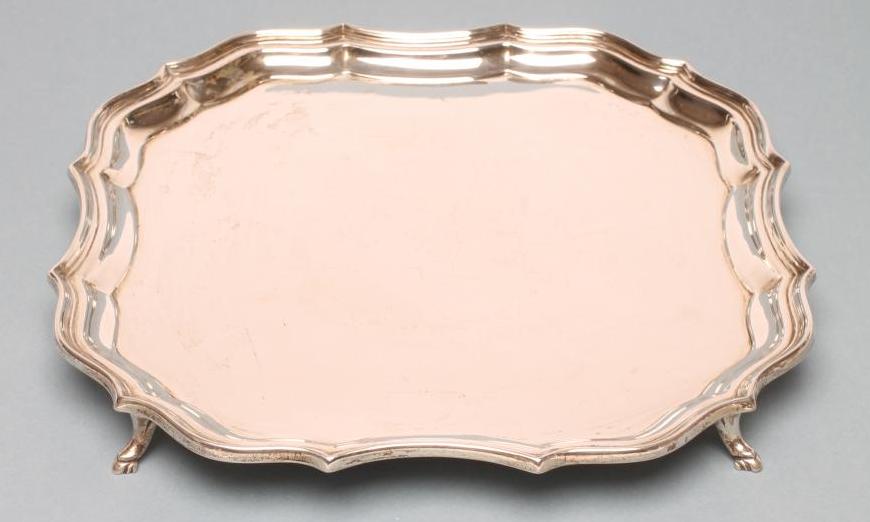 A SILVER SALVER, maker Barker Bros., Chester 1919, of square form with pie-crust rim, raised upon