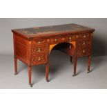 AN EDWARDIAN MAHOGANY AND FOLIATE MARQUETRY DESK of oblong form crossbanded with stringing, the